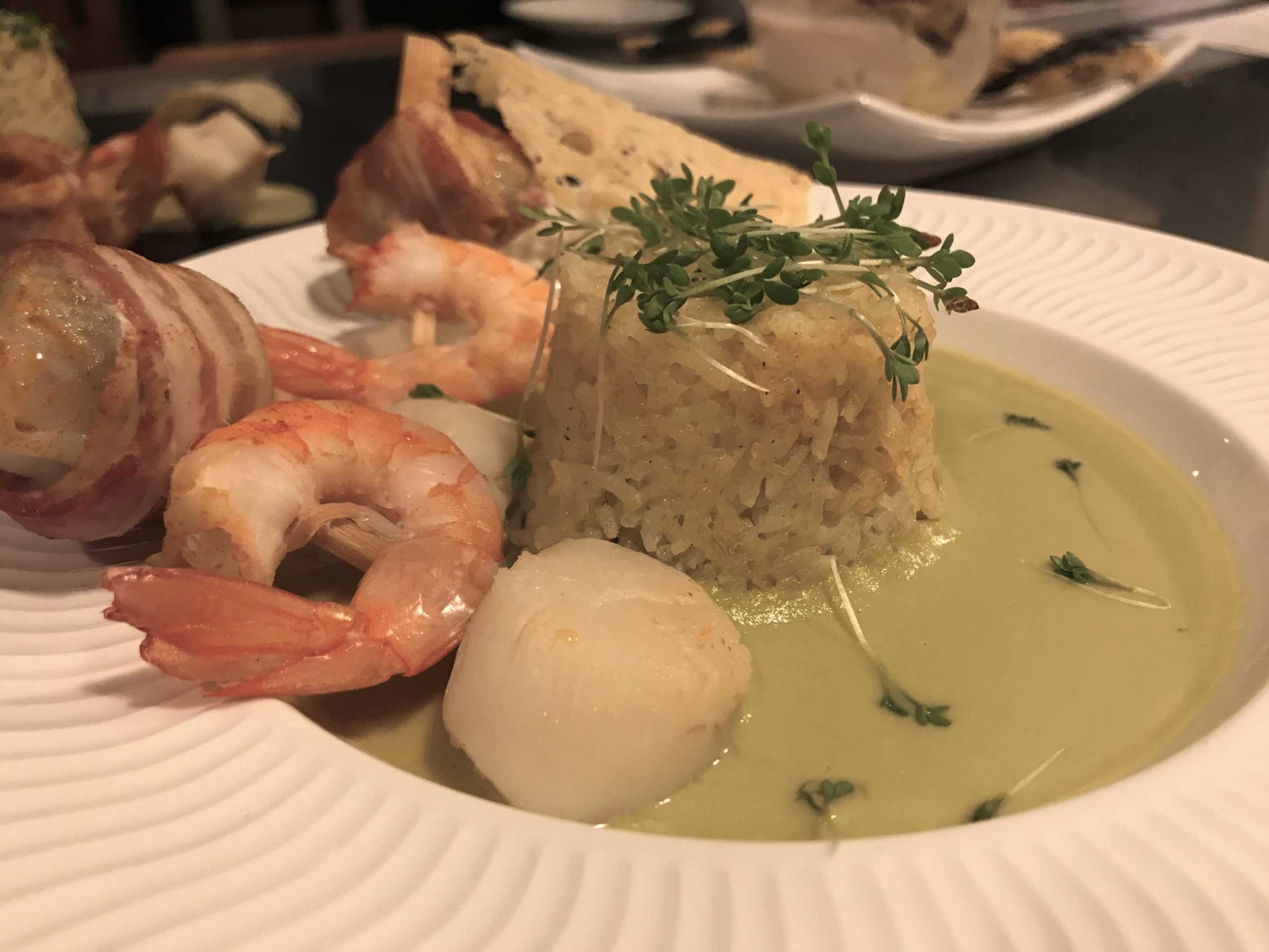 Brochettes marines en robe de lard, riz parfumé sauce parmesan.